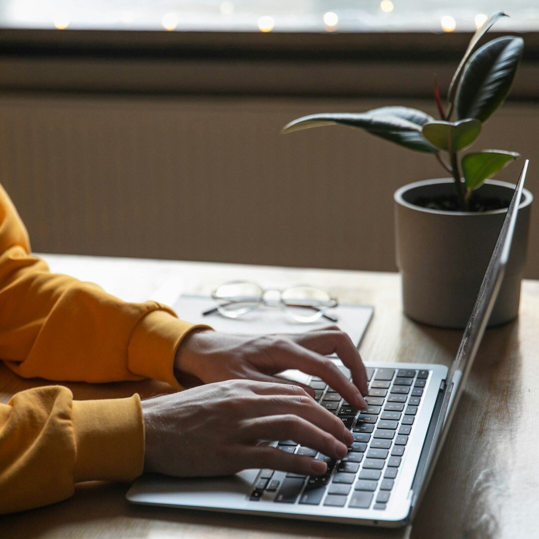 Editor writing notes at a desk with a laptop